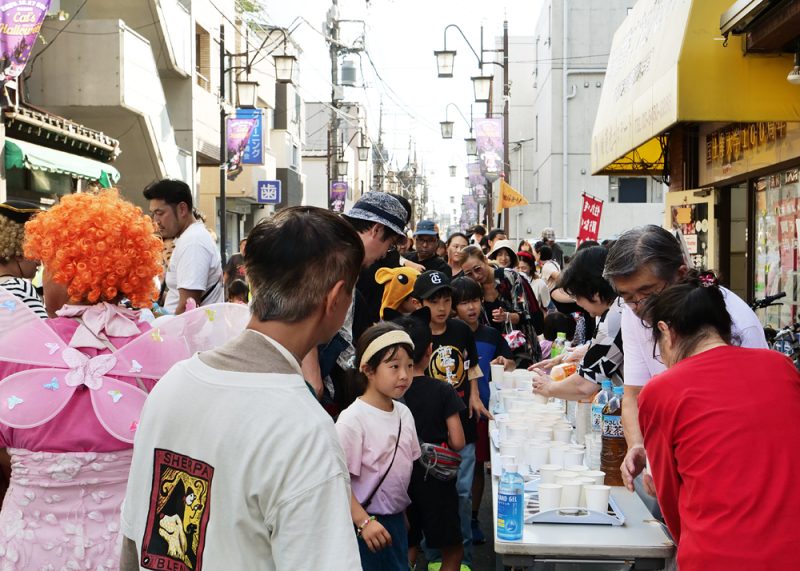 サンバパレード　梅が丘商店街で休憩中、飲み物を受け取るこどもたち